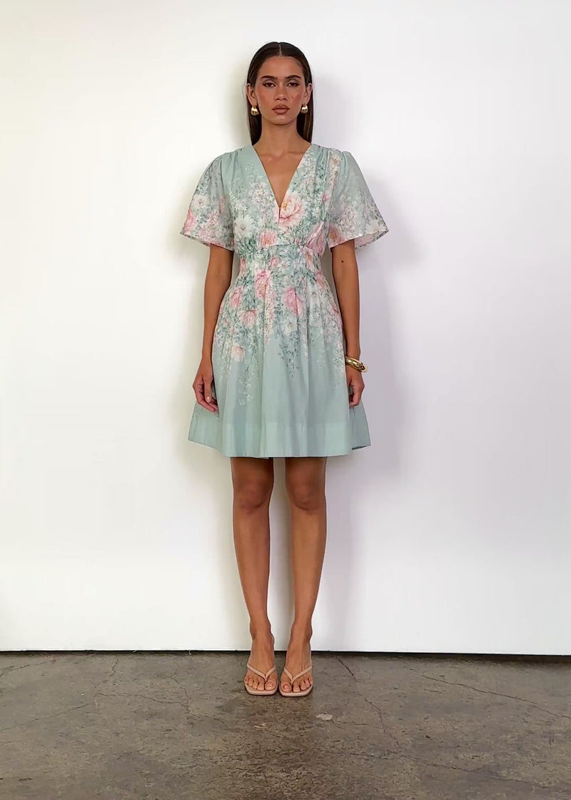 Video: Saylor Mini Dress in Seafoam Peony with a V-neckline, short flutter sleeves, fitted waist, softly gathered bodice and a flared mini-length skirt, finished in a delicate pink and green floral print.
