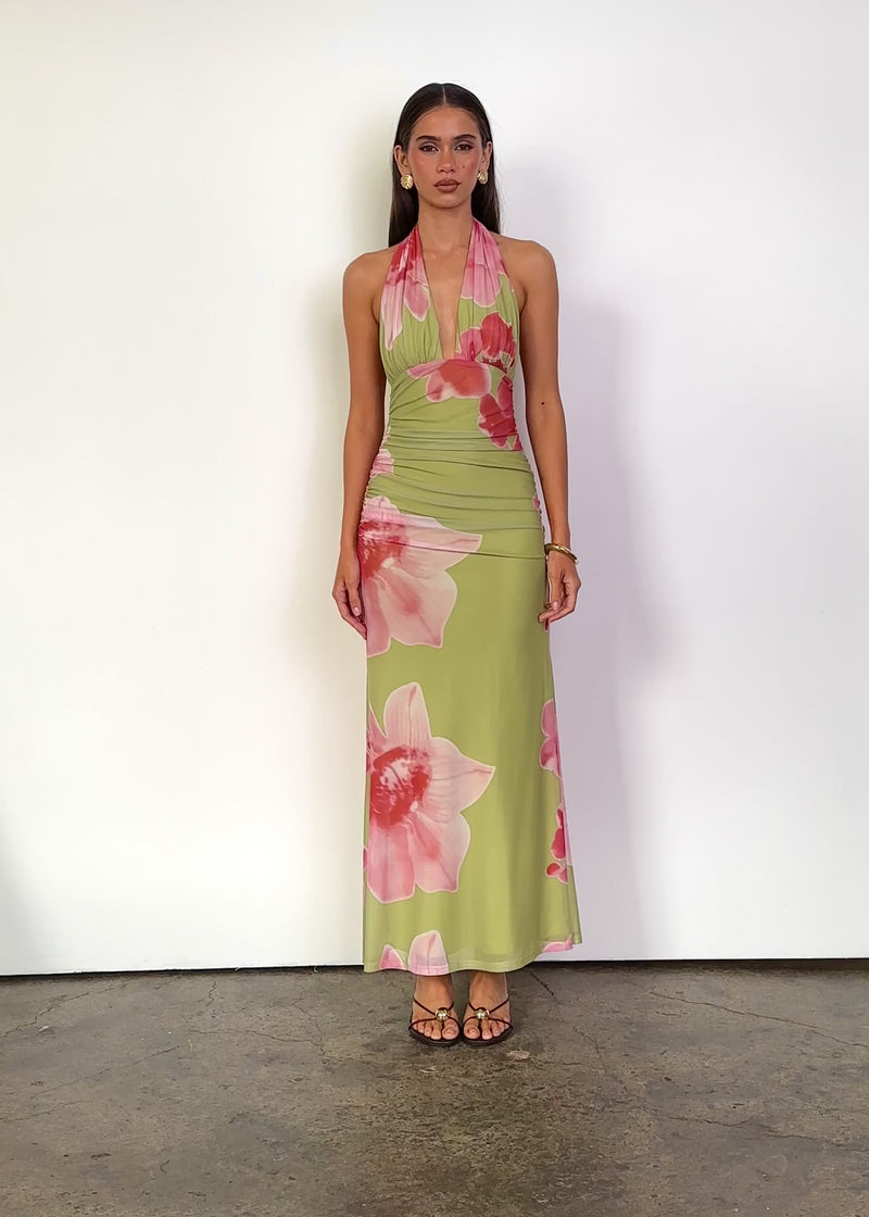 Video: Erika Halter Mesh Maxi Dress in Matcha Bloom with a plunging halter V-neckline, sleeveless open-shoulder design, gathered bust, fitted ruched waist and hips, and a streamlined maxi-length silhouette in sheer floral mesh.